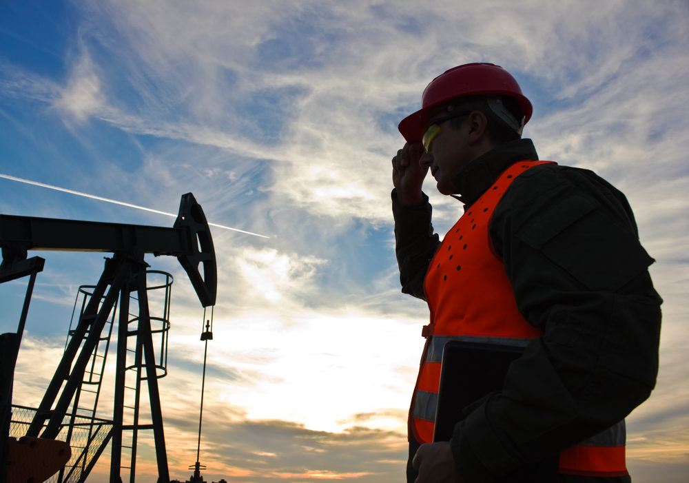 worker in the oil field industry at dusk,