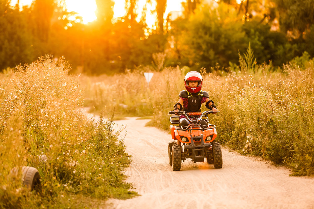 The little girl rides a quad bike ATV