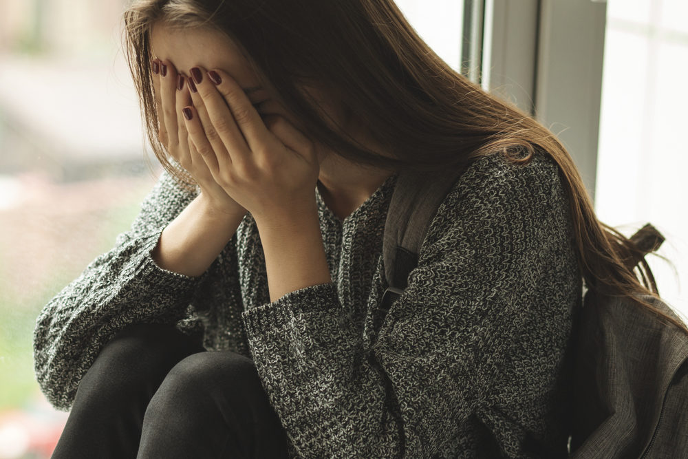 young woman cries at school