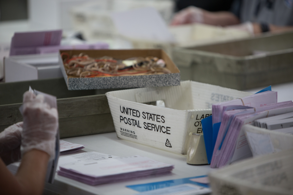 Election poll workers count vote by mail ballots from United States Postal Service boxes during Nevada's 2020 primary election.