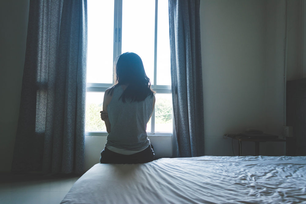 Woman alone looking out a window