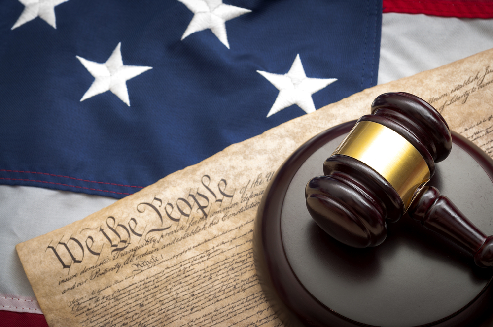 American flag, US constitution and a judge's gavel symbolizing the American justice system or the Judicial Branch of government