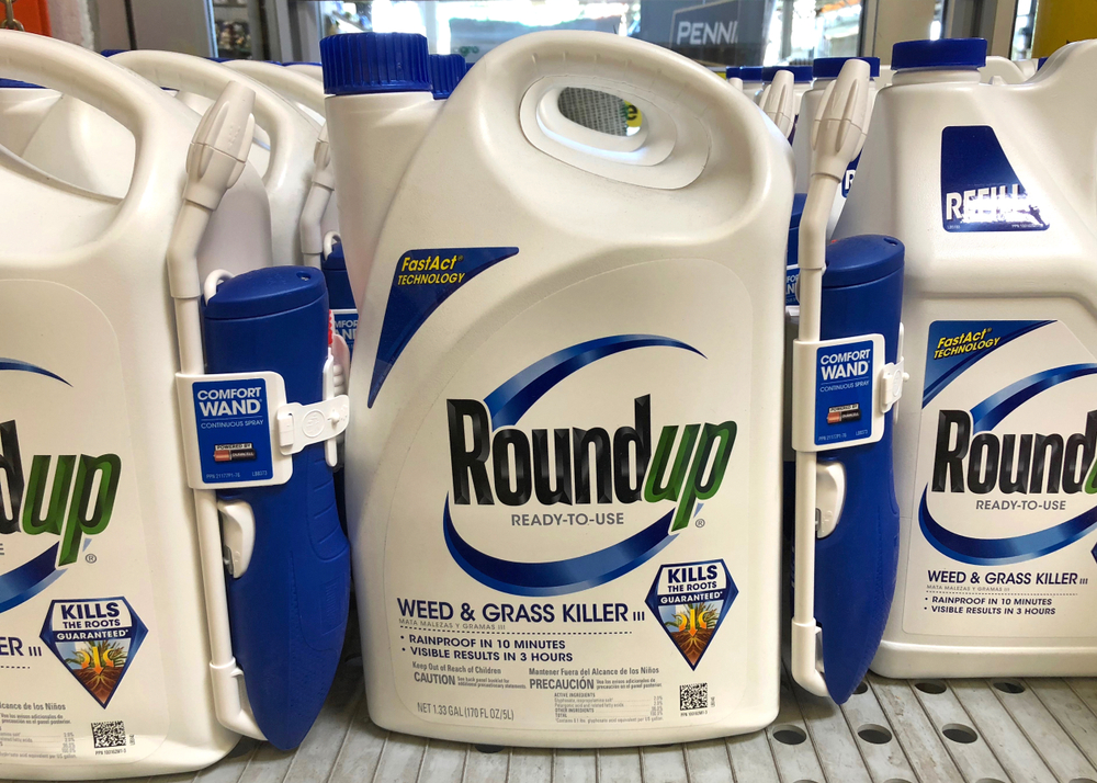 Garden supply store shelf with containers of RoundUp weed killer.