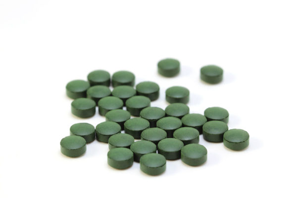 Many green pills on a white background