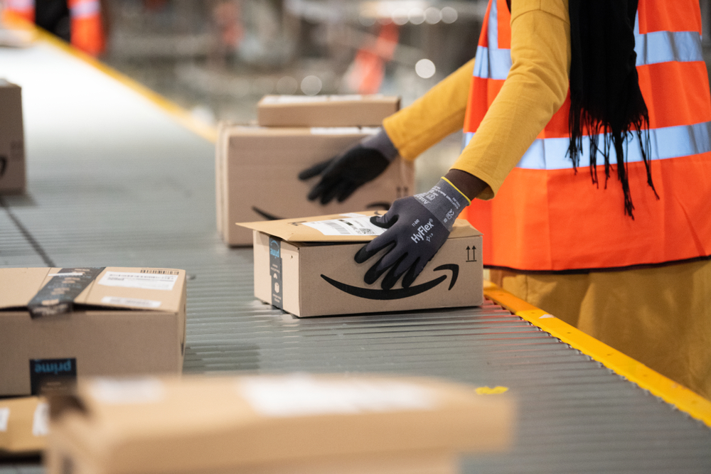 Packages are sorted by amazon workers on conveyor