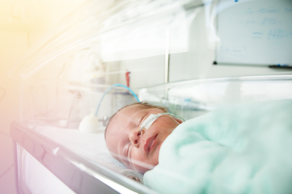 Little premature born child through hospital crib