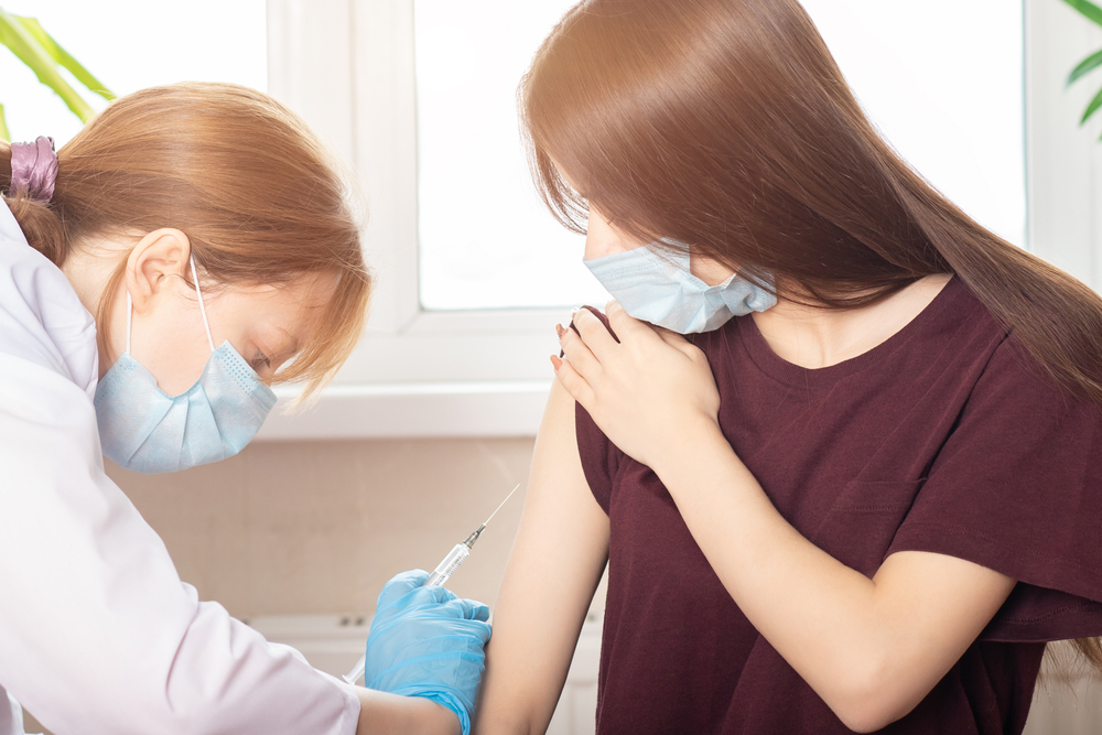 a nurse holding a syringe before administering a dose of coronavirus vaccine from covid-19