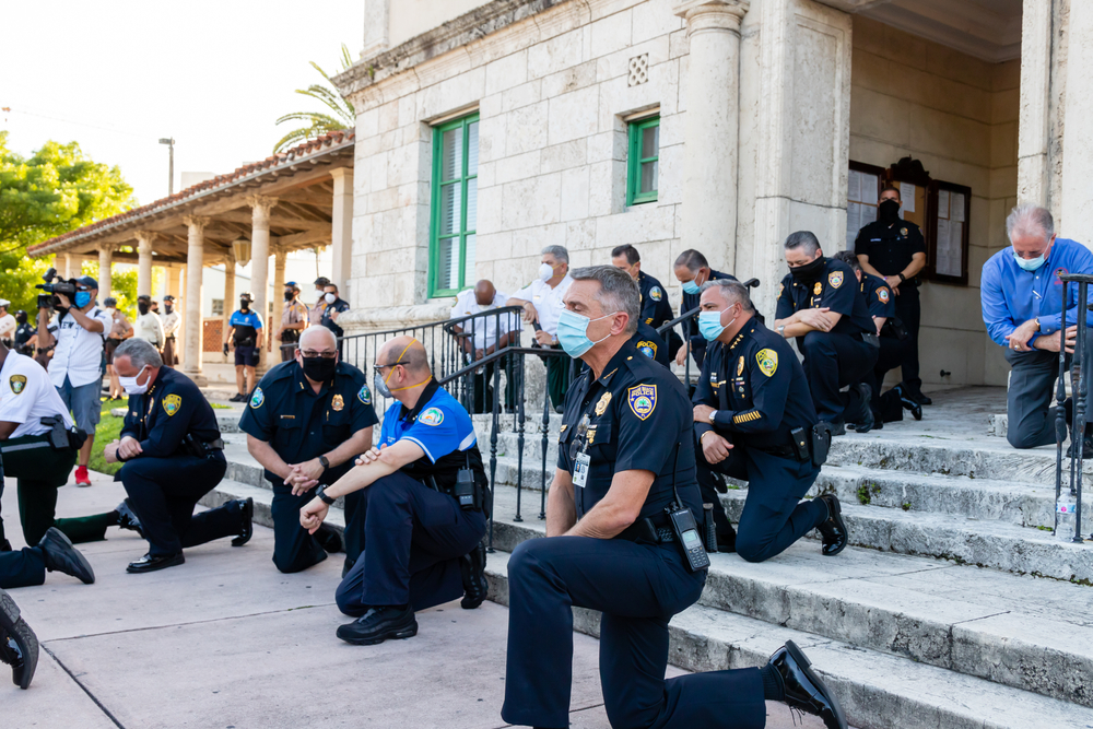 Coral Gables, Florida - May 30, 2020: Police kneeling along side out of view protesters during protest for George Floyd