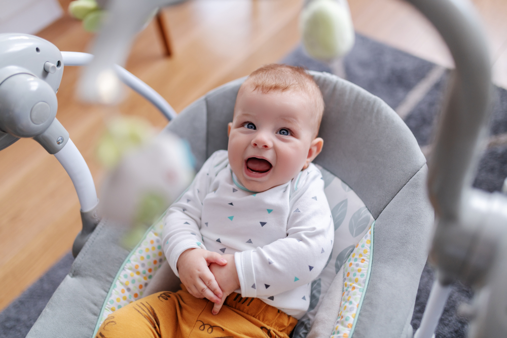 Adorable caucasian 6 months old baby boy sitting in his rocker chair