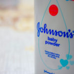 Close up image of white bottle of Johnson's baby powder isolated on table