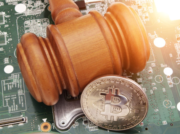 gavel and bitcoin coin on computer circuit board