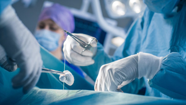 Close-up on Hands of the Professional Surgeon Suture Wound after Successful Surgery.