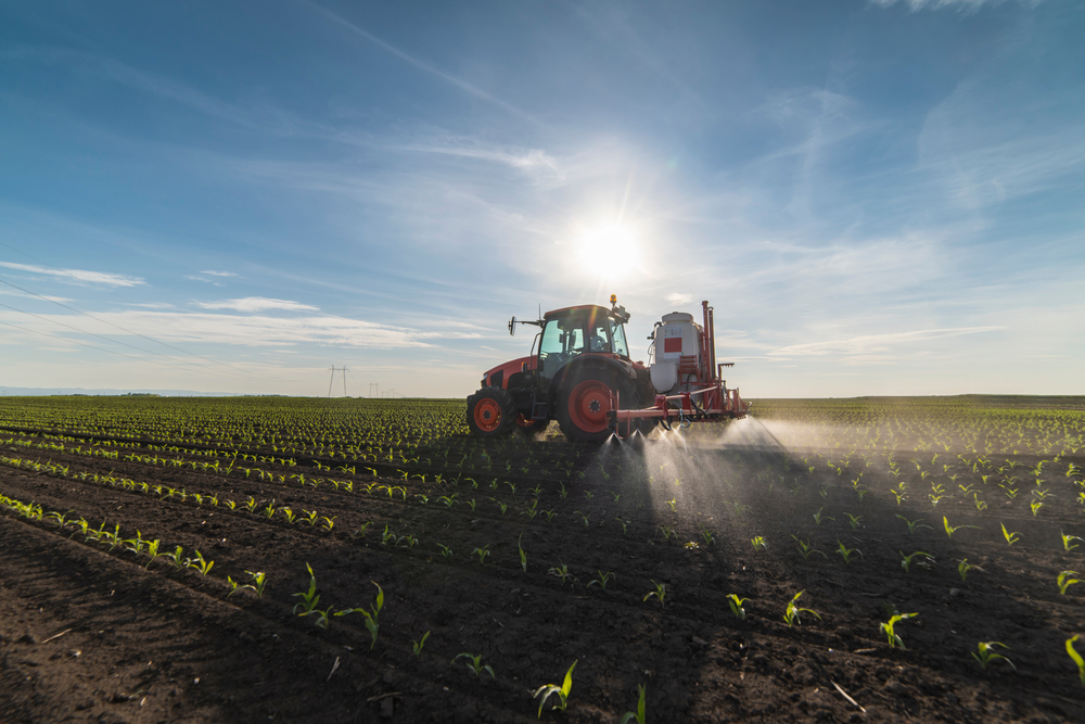 Tractor spray fertilize field with insecticide herbicide chemicals in agriculture field