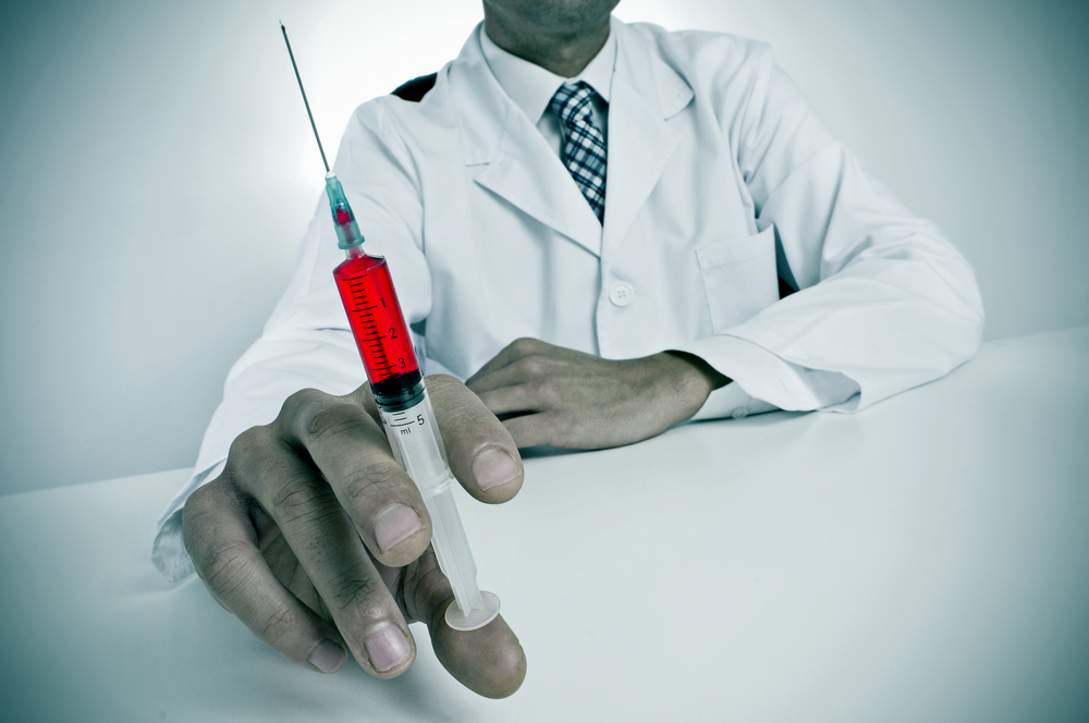 a sinister doctor sitting in a desk holding a syringe