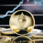 Ethereum cryptocurrency, physical coin close-up, in front of a price chart.