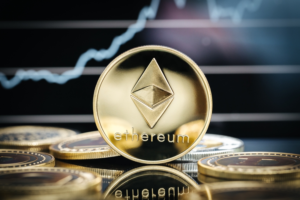 Ethereum cryptocurrency, physical coin close-up, in front of a price chart.