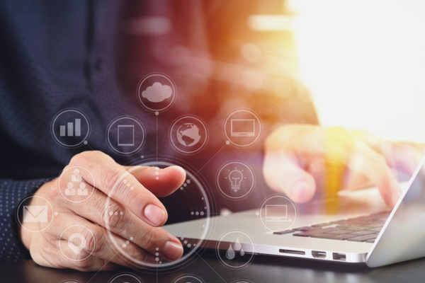 close up of businessman hand working with laptop computer in modern office with virtual icon diagram