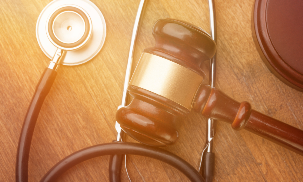 Wooden gavel and stethoscope on wooden background