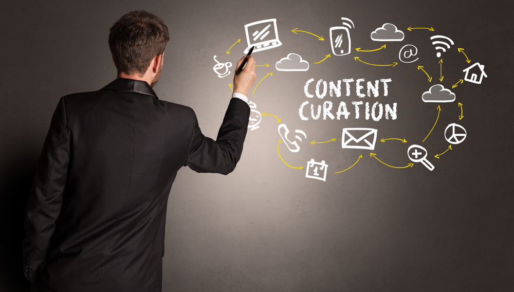 businessman drawing social media icons with CONTENT CURATION inscription, new media concept