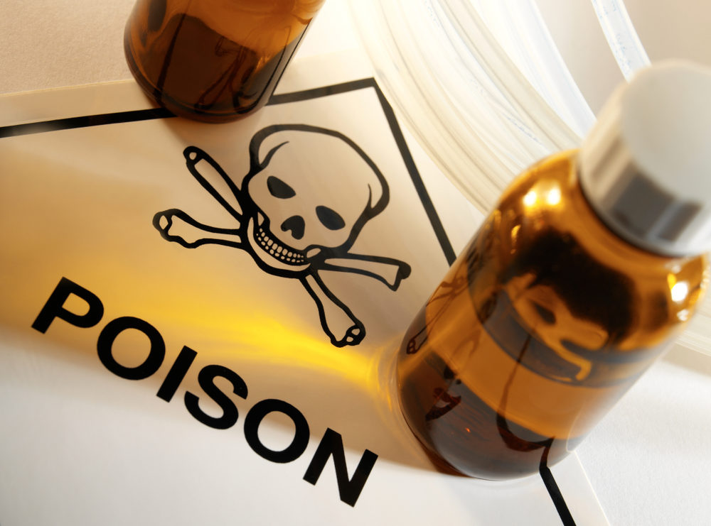 Two unlabeled vials of fluid sit on a POISON sign with skull and crossbones