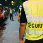 security guard with blurred crowd of audience or diversity people at concert venue entrance.