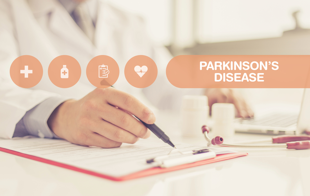 Parkinson's disease images over a doctor's hand at a desk