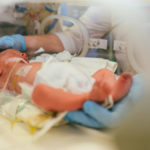Three-day-old newborn baby in intensive care unit in a medical incubator.