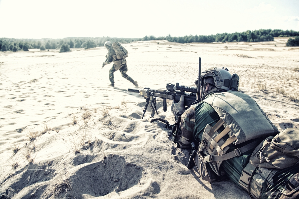 $soldiers on sand firing weapons