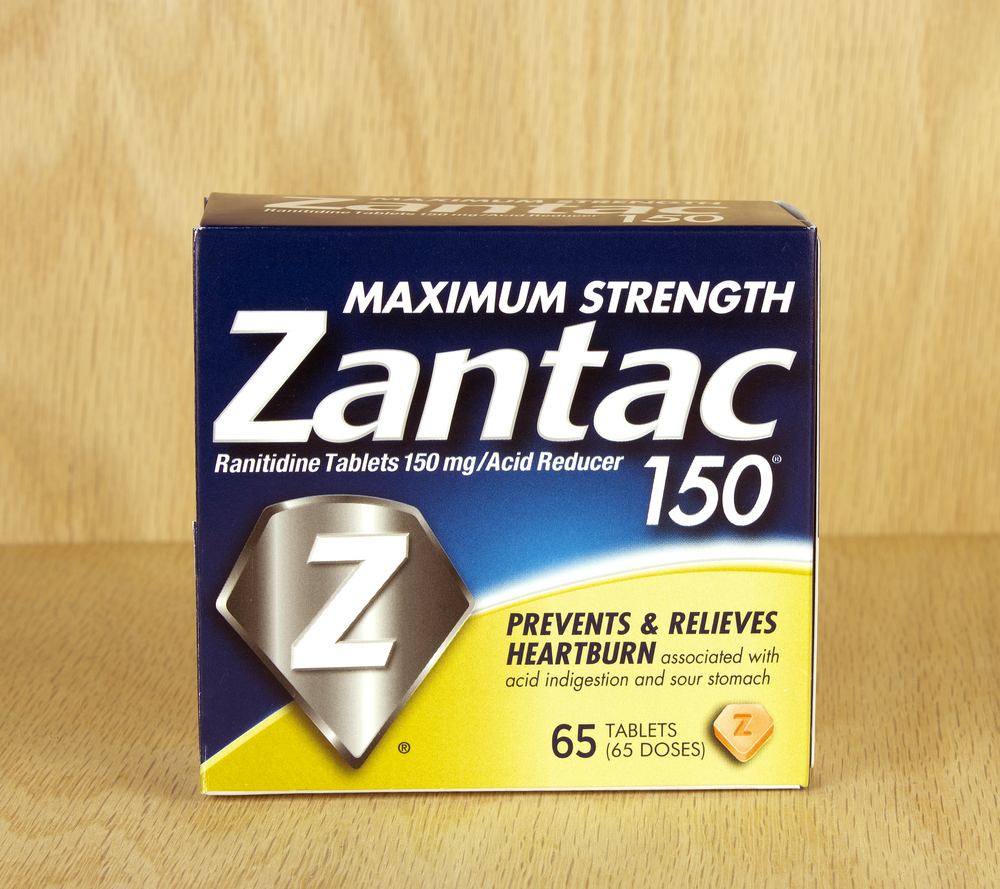 A box of Zantac acid indigestion tablets with a wood background.