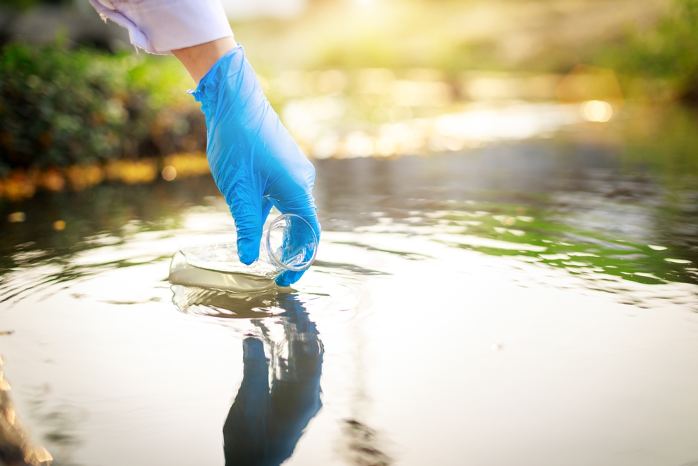 Scientist takes samples of wastewater in a test tube.