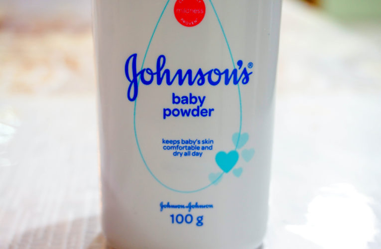 Close up image of white bottle of Johnson's baby powder isolated on table.