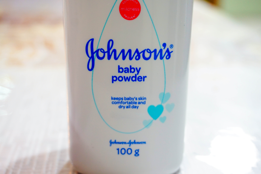 Close up image of white bottle of Johnson's baby powder isolated on table.
