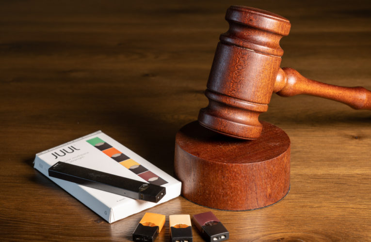 Juul e-cigarette or nicotine vapor dispenser box with Judge's gavel for lawsuit