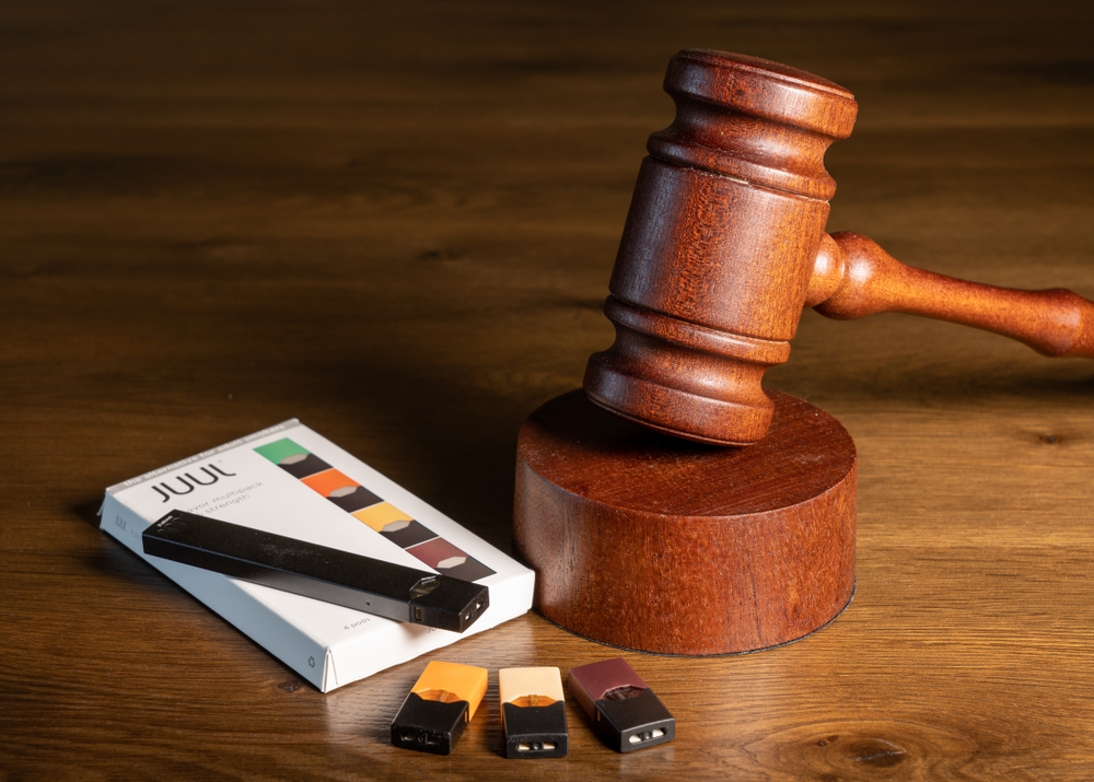 Juul e-cigarette or nicotine vapor dispenser box with Judge's gavel for lawsuit