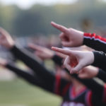 High school cheerleaders point as part of a routine.
