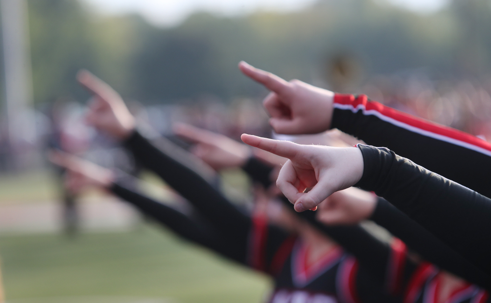 High school cheerleaders point as part of a routine.