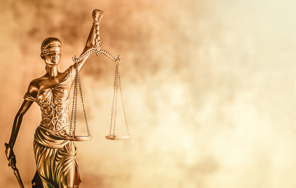 scales of justice with blurred light background