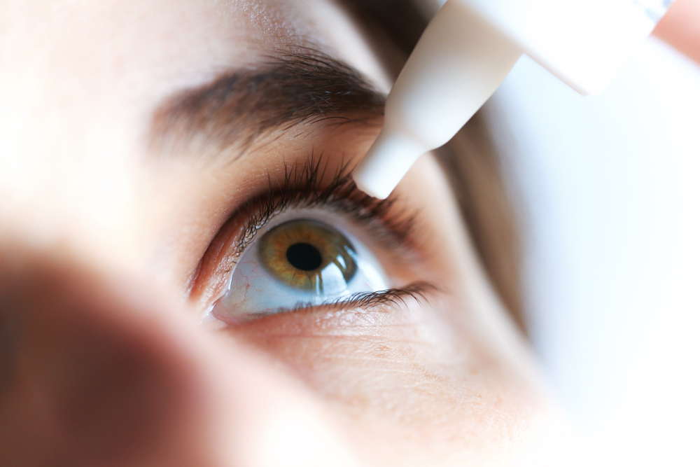 woman applying artificial tears closeup