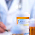 Doctor with RX prescription drug bottle selective focus