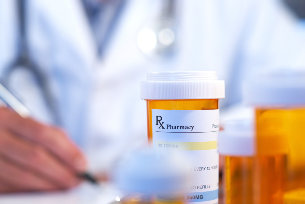 Doctor with RX prescription drug bottle selective focus