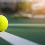 Close up tennis ball on court background