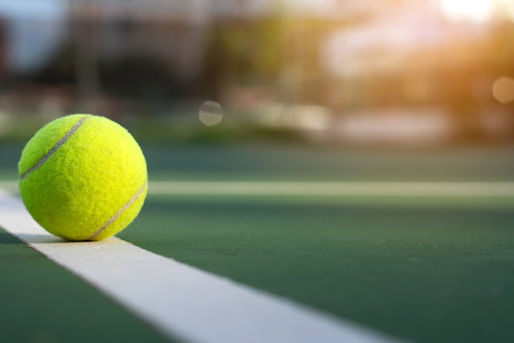 Close up tennis ball on court background