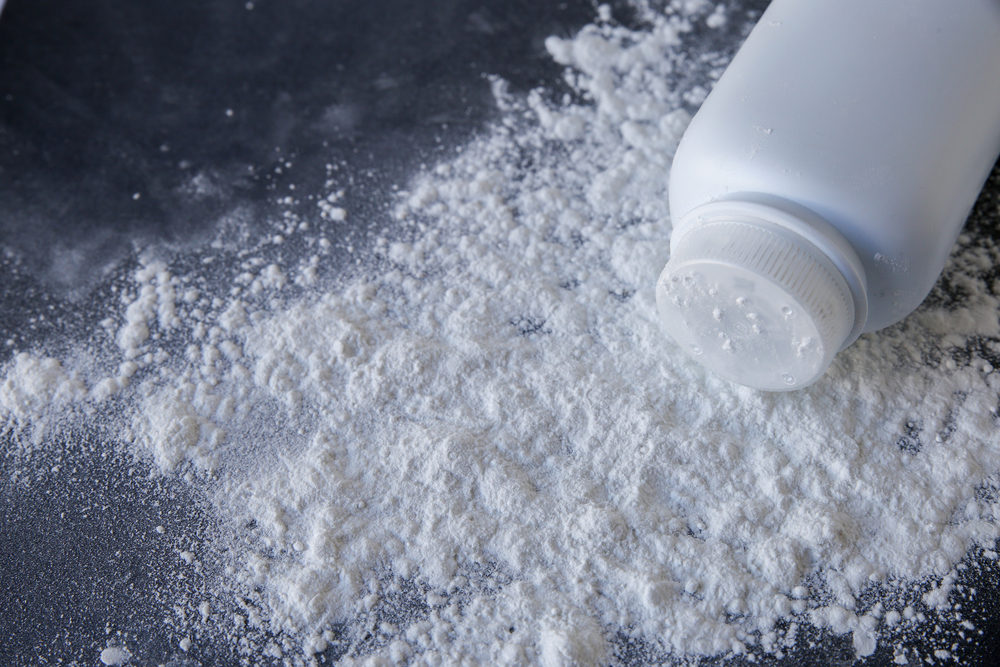 A talcum bottle knocked over with powder spilling out