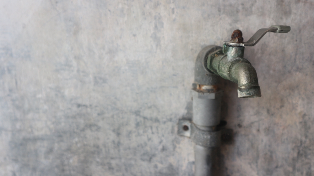 water faucet attached to a concrete wall