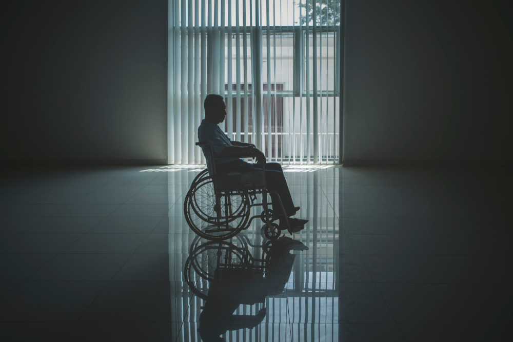 lonely elderly man looks sad in the retirement home while sitting in the wheelchair