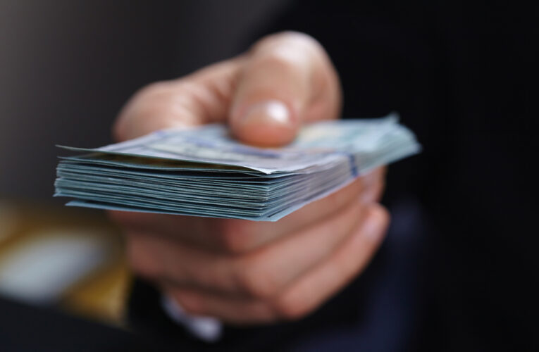 closeup of hand offering cash