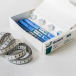 a box of ozempic injectors with cartridges on a white table with a measuring tape