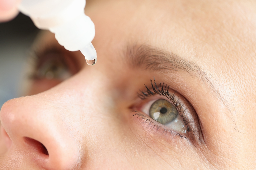 closeup of a woman applying eye drops