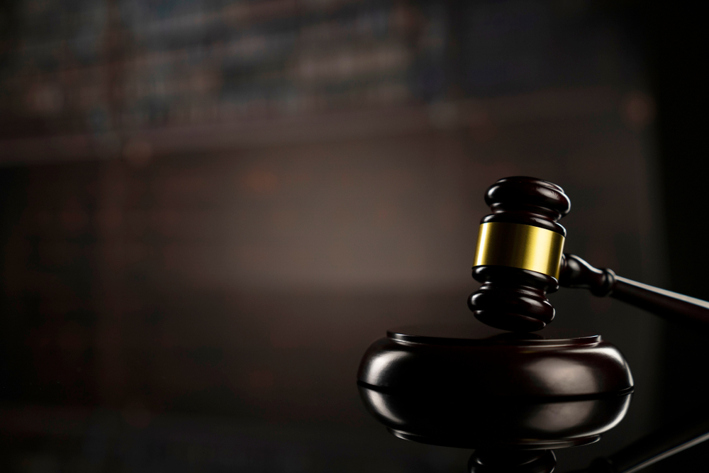 closeup of a gavel in a law office with legal library in background