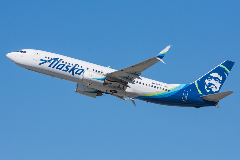 alaska airlines boeing 737 in flight against blue skies